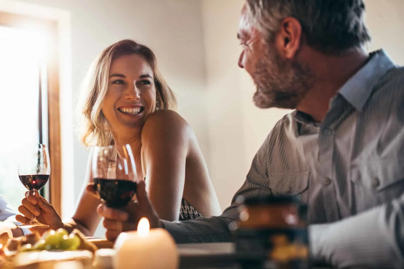 a smiling loving couple talking while drinking wine