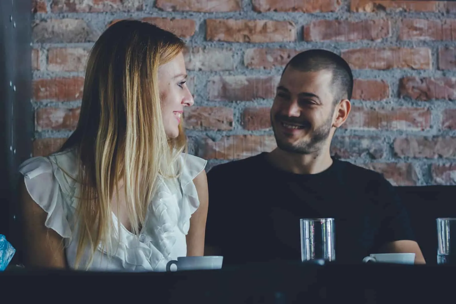 couple sitting in cafe looking at eachother