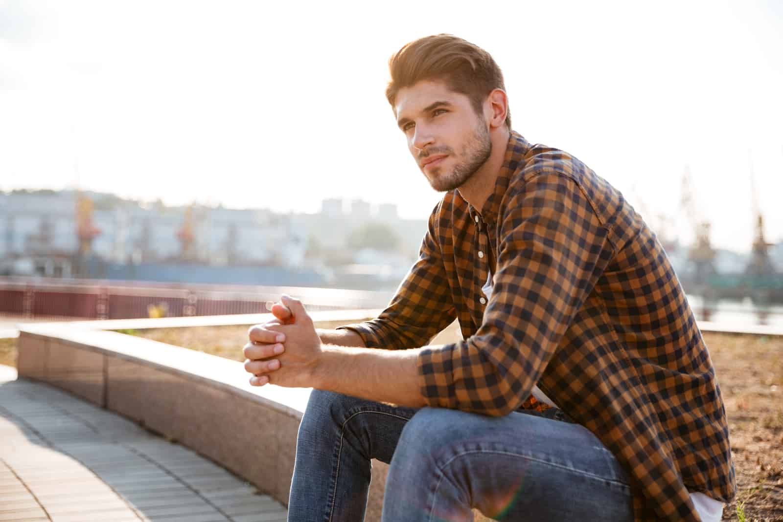 hombre sentado en la pared exterior