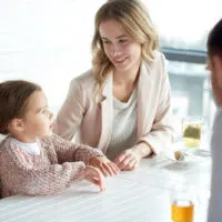 a man and a woman are sitting at a table with a child