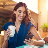 smiling woman looking at mobile phone