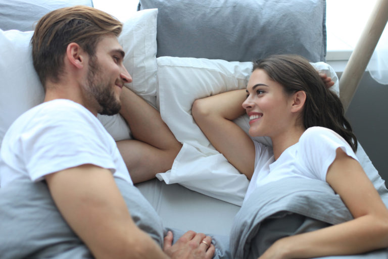 young couple lying in the bed and talking
