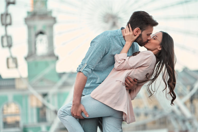 una pareja de enamorados besándose al aire libre