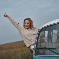 happy woman hanging from window of car