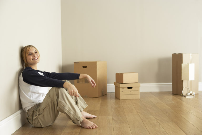 woman sitting on floor with cardboard boxes behind her
