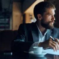man sitting looking through window