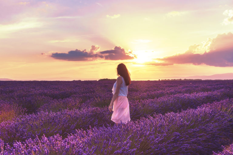 mulher a caminhar num campo de flores