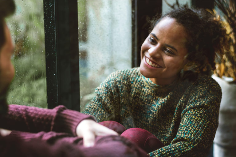 a man and a woman sit by the window and talk