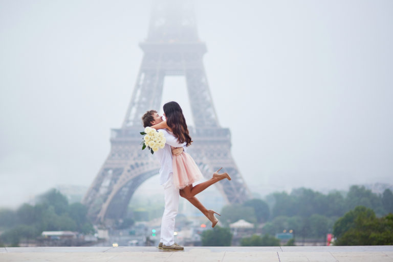 man hugging a woman with white roses