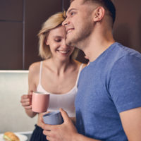 a smiling loving couple standing in the kitchen