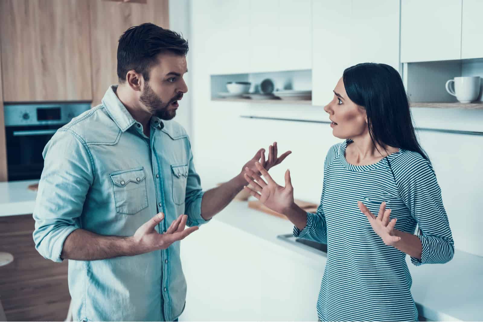 un uomo e una donna sono in piedi in cucina a discutere