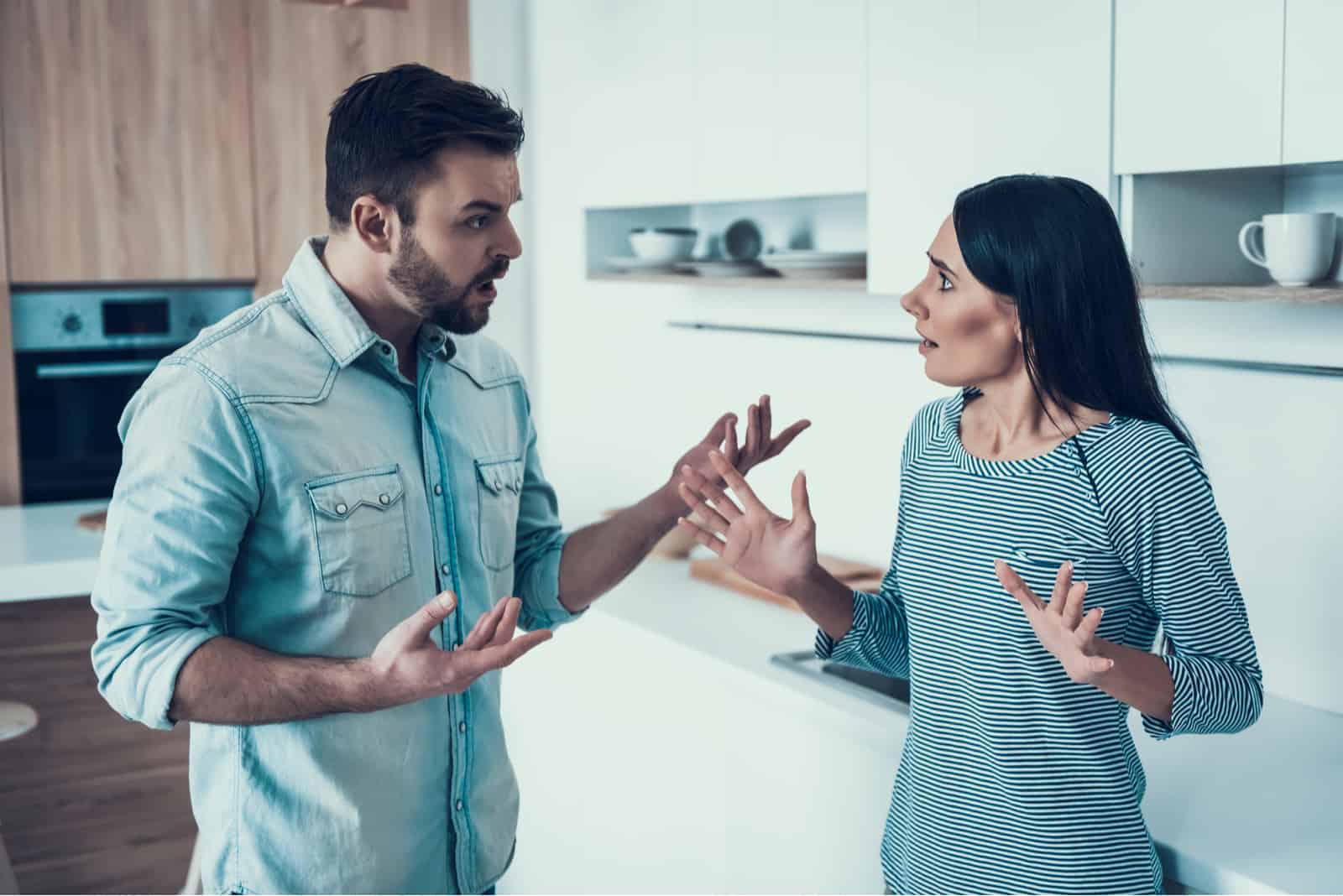 um homem e uma mulher estão na cozinha a discutir