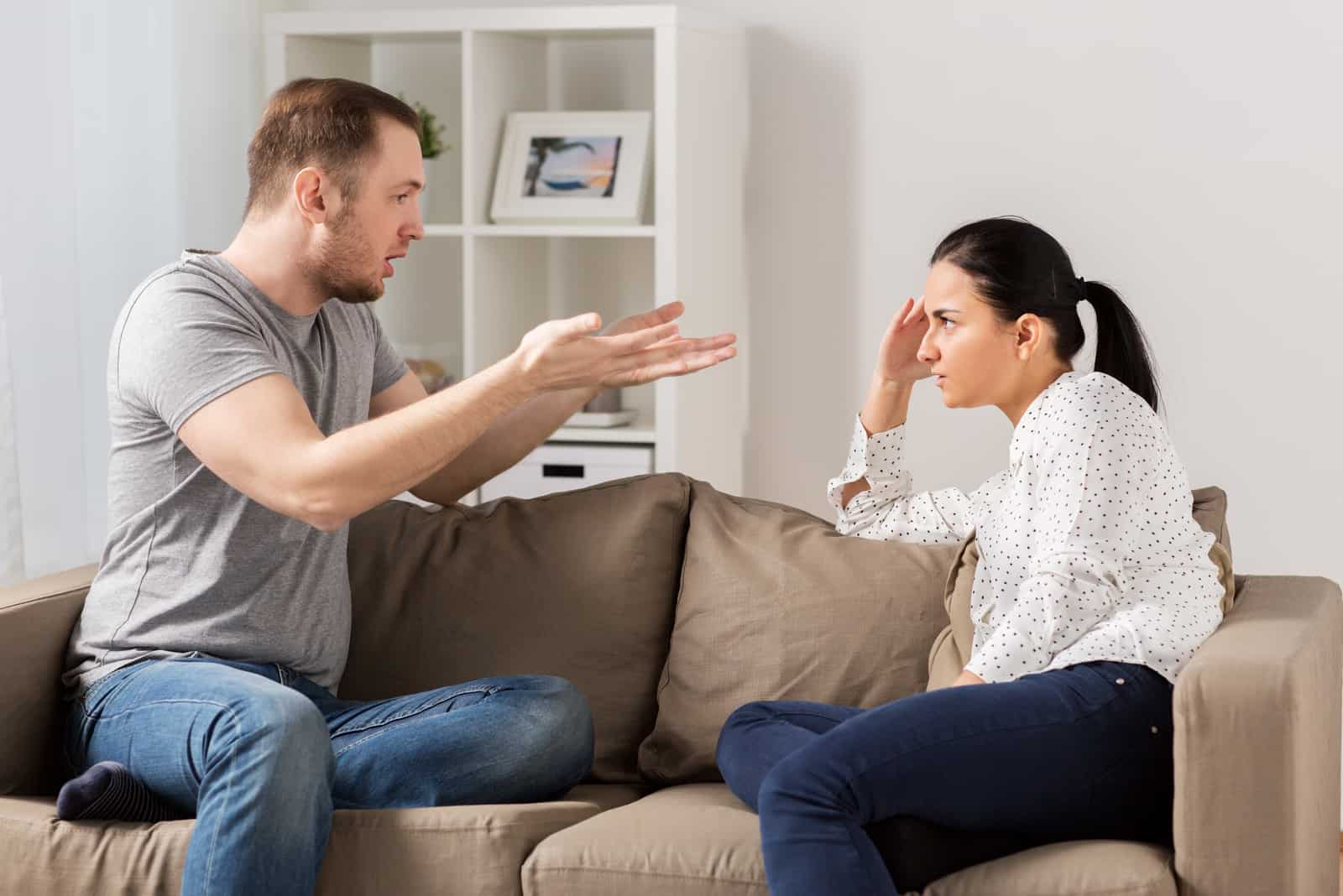a man quarrels with a woman while sitting on the couch