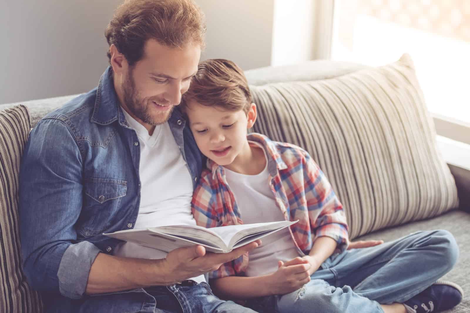 un uomo seduto con un bambino che legge un libro