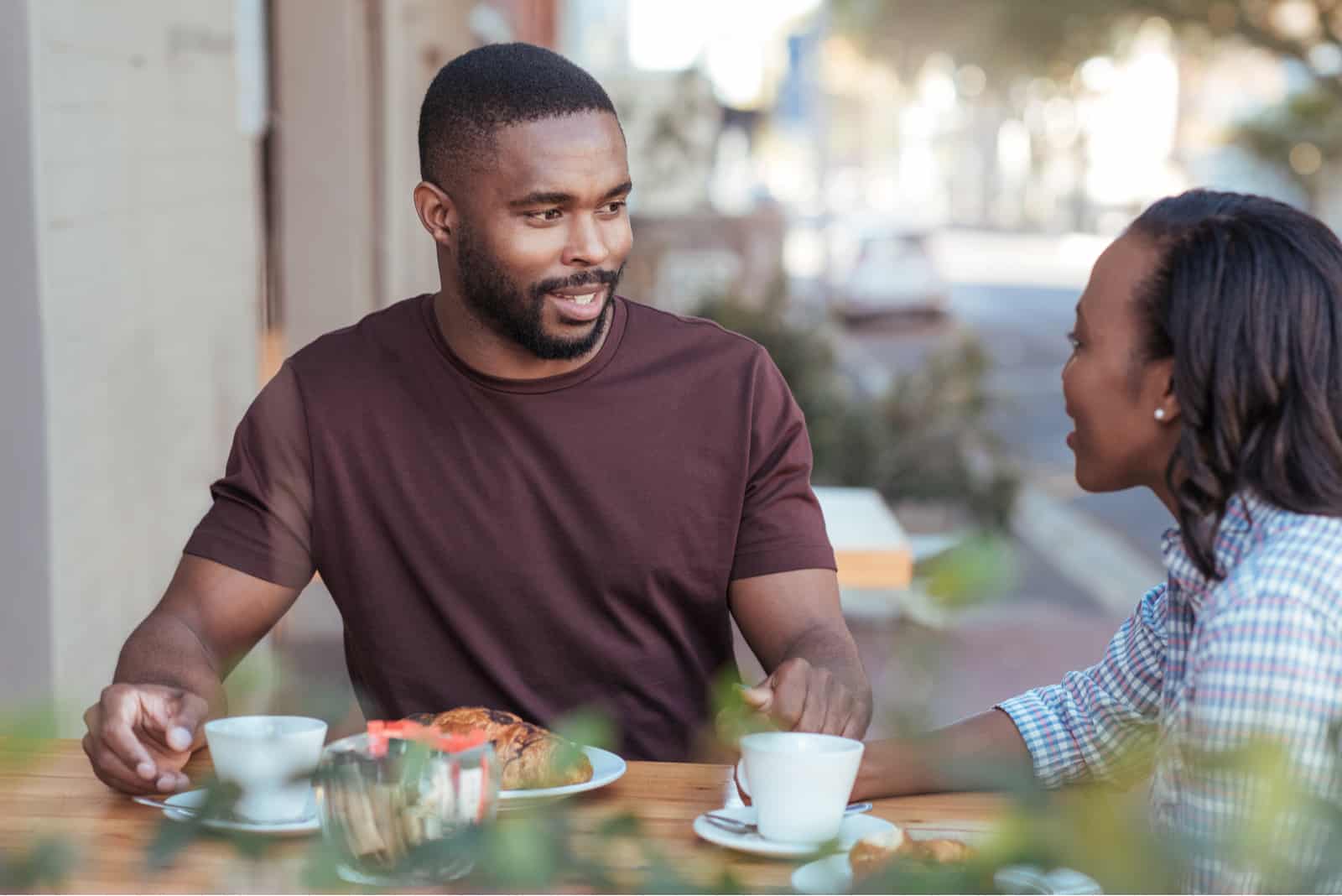 a smiling loving couple sitting outdoors and talking