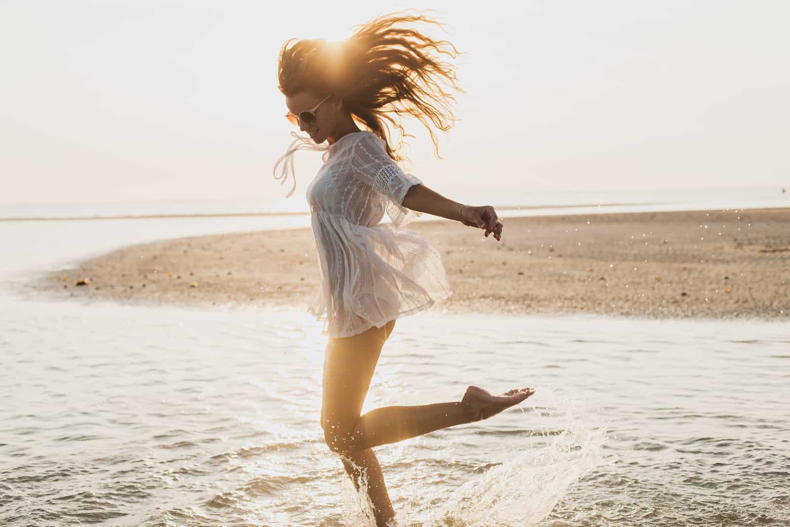 a smiling woman running across the sea