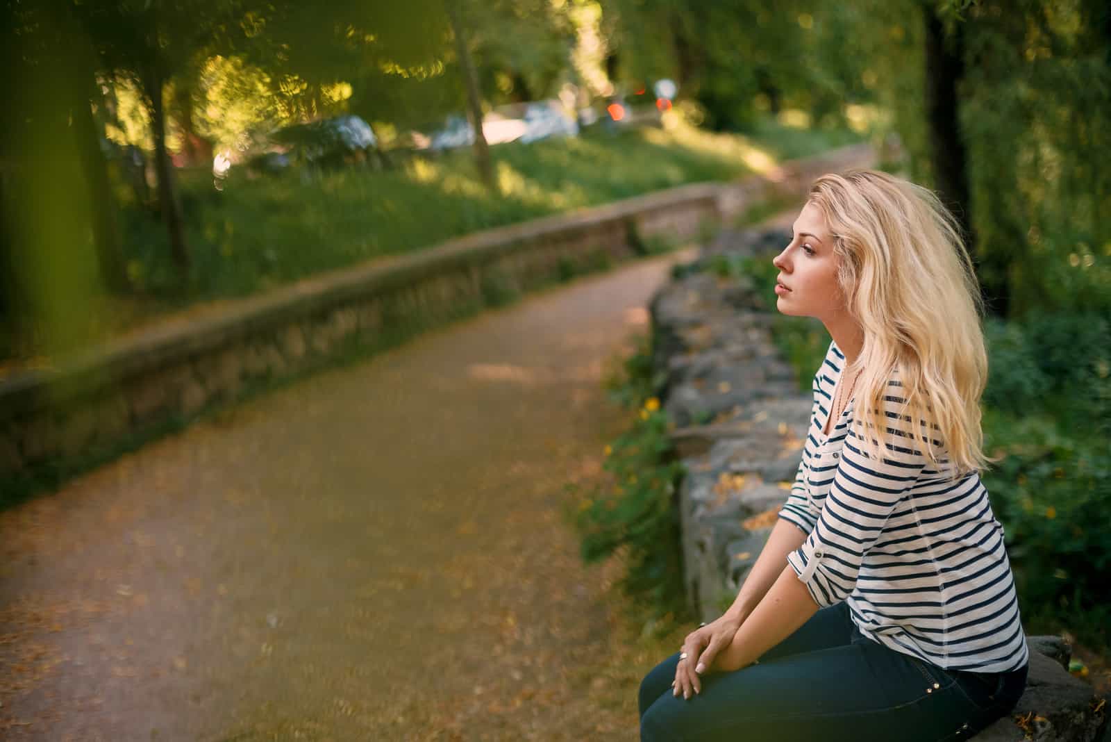 a woman with long blonde hair sits on the back