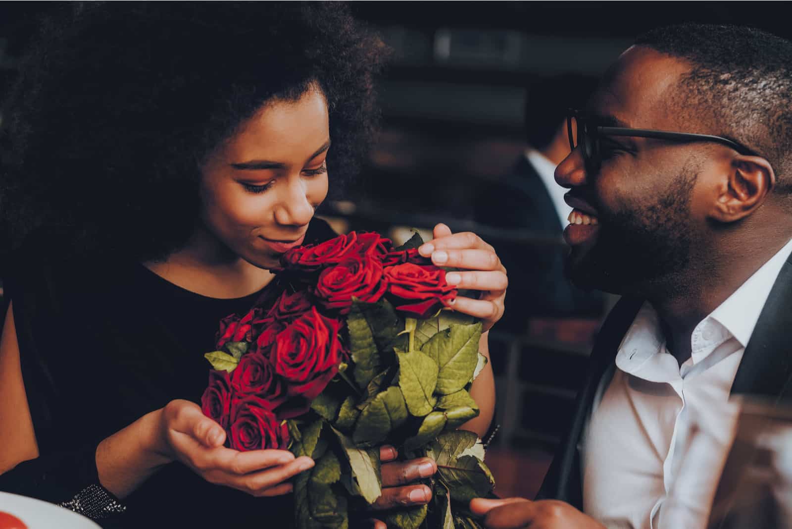 novio sorprendiendo a su novia en una cita con rosas rojas