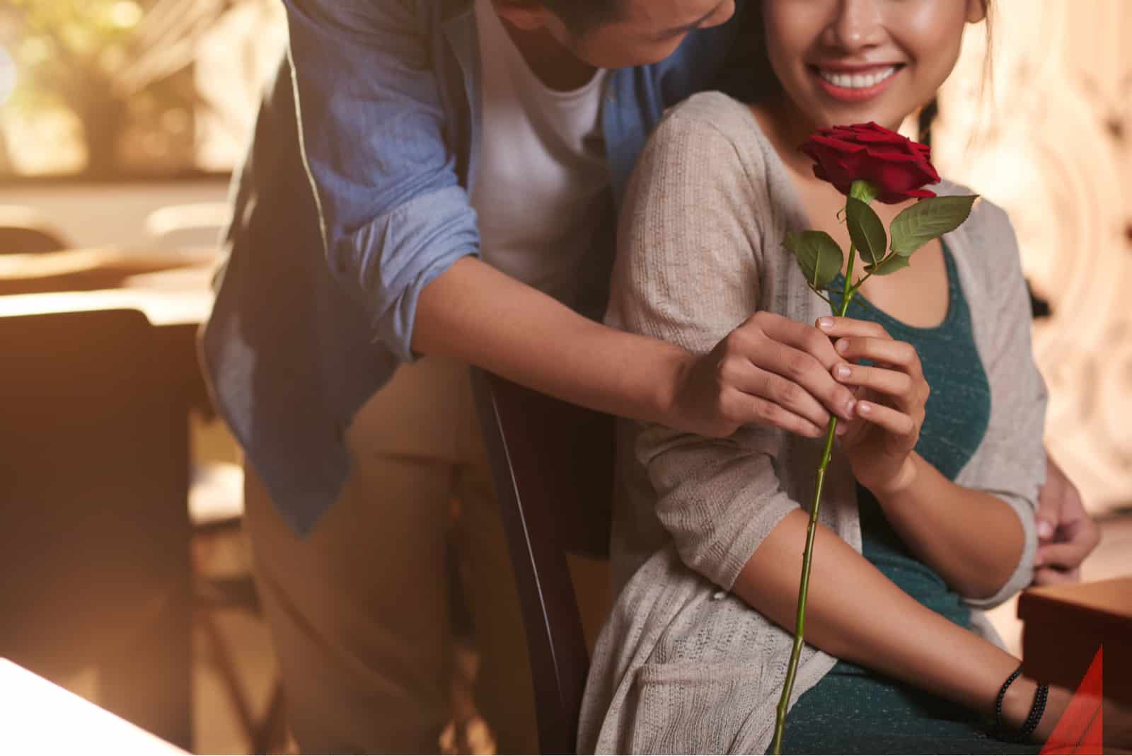 boyfriend surprising his girlfriend with red rose