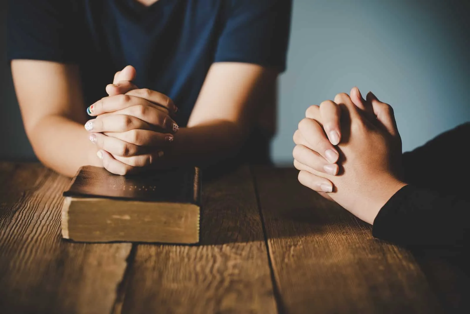 couple praying together with the Bible on the table