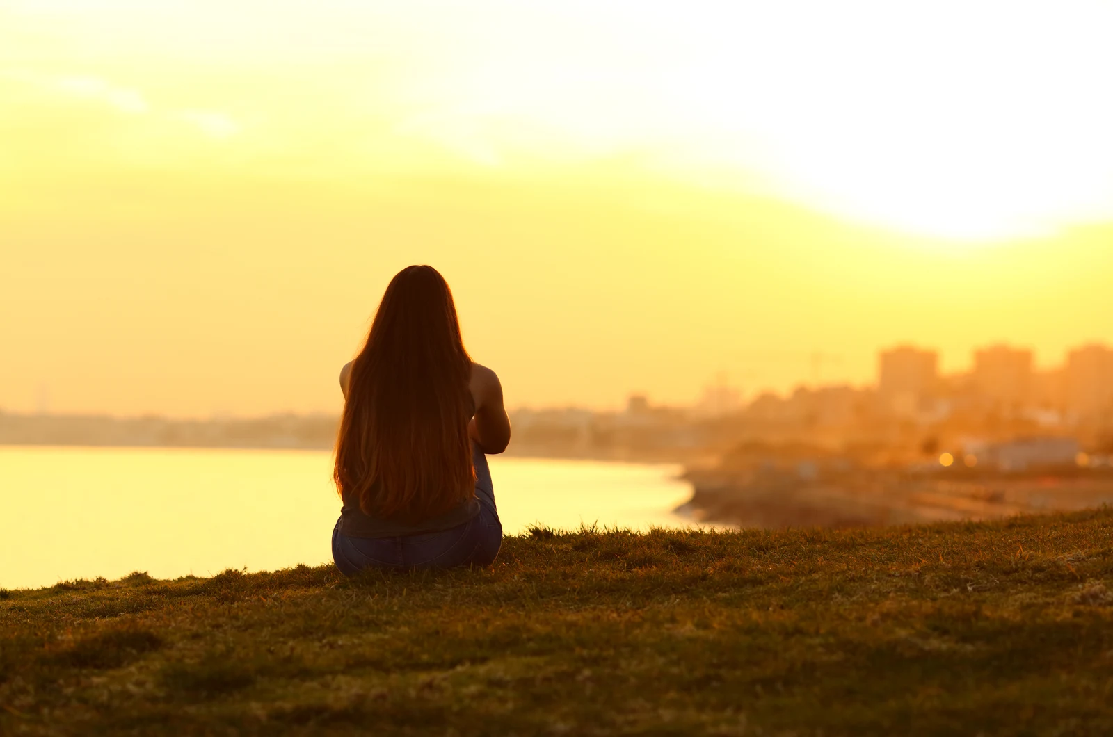 girl sitting looking at sunset