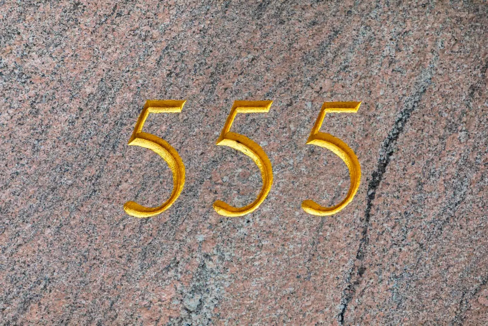 golden number 555 on stoned background