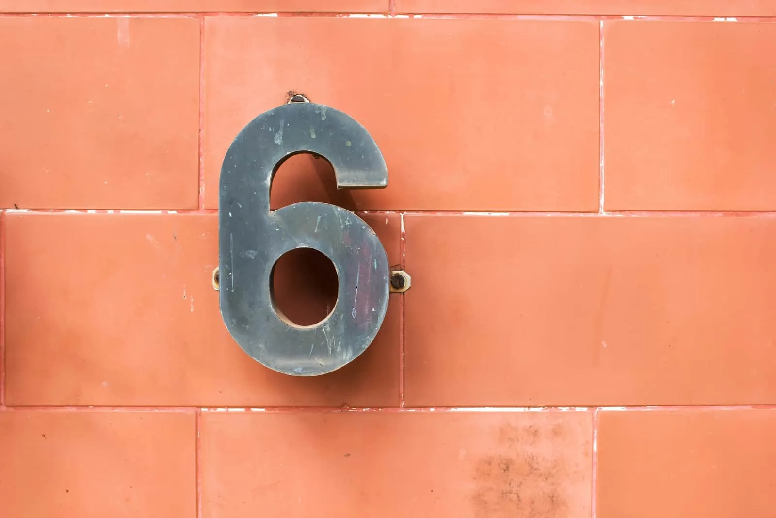 grey number 6 hanging on bricks