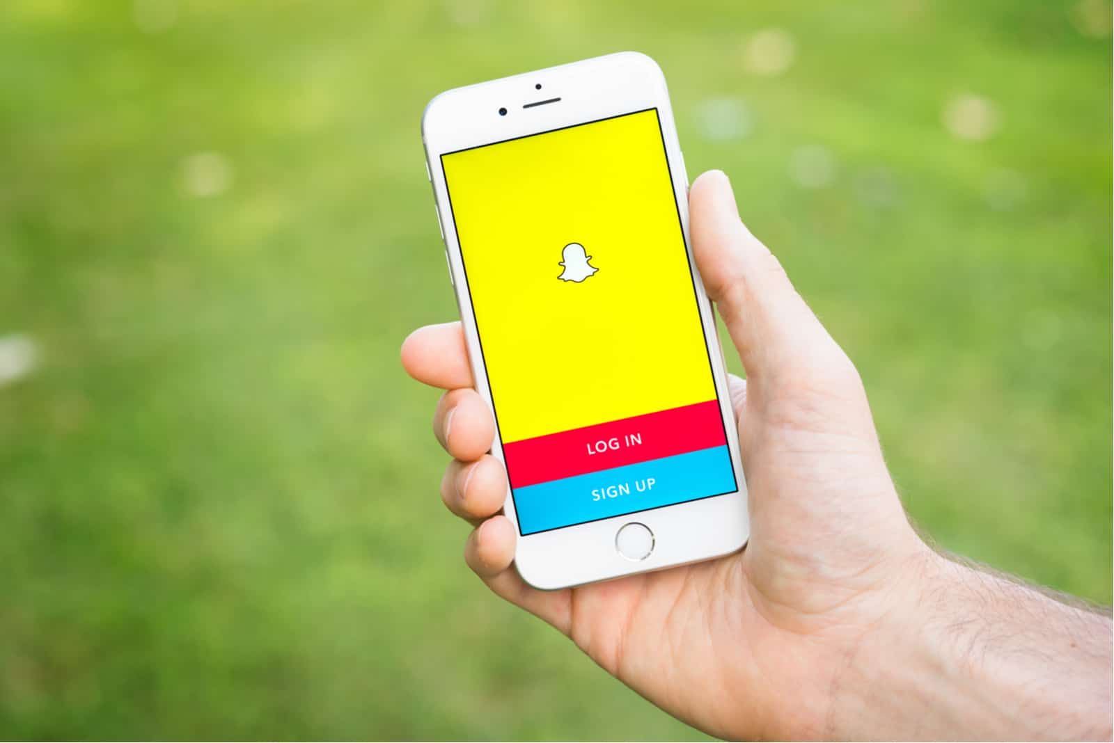 man holding mobile phone in hand with snapchat login on it