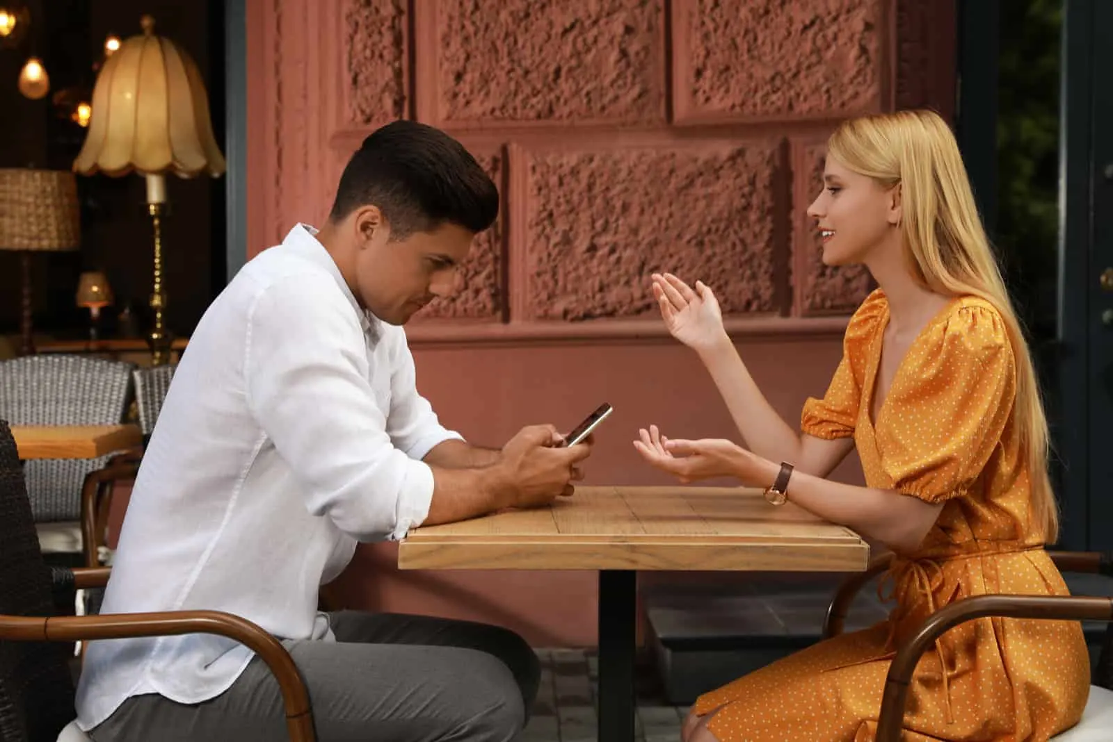 man ignoring woman on date