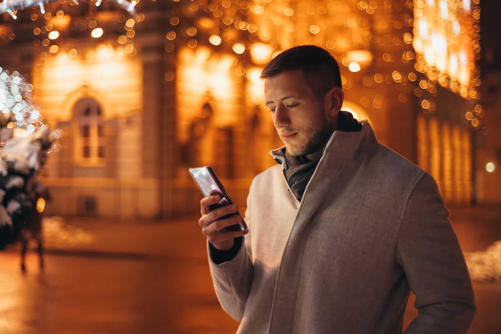 man walking at night texting