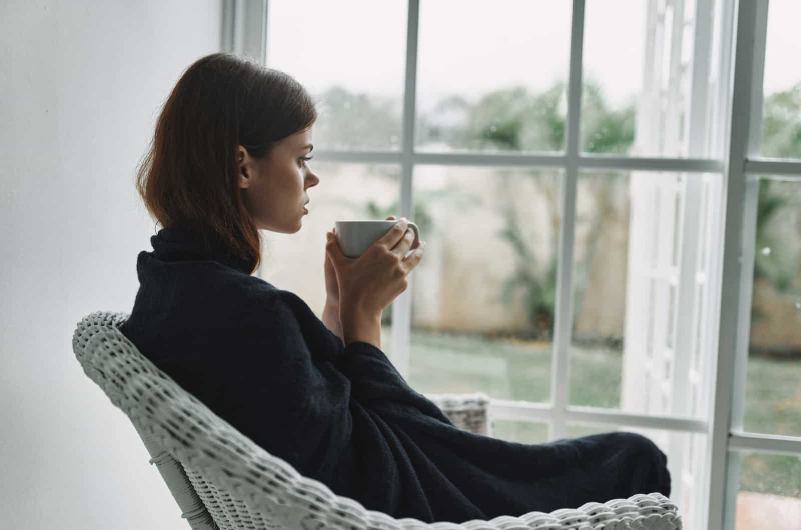 sad girl looking through window