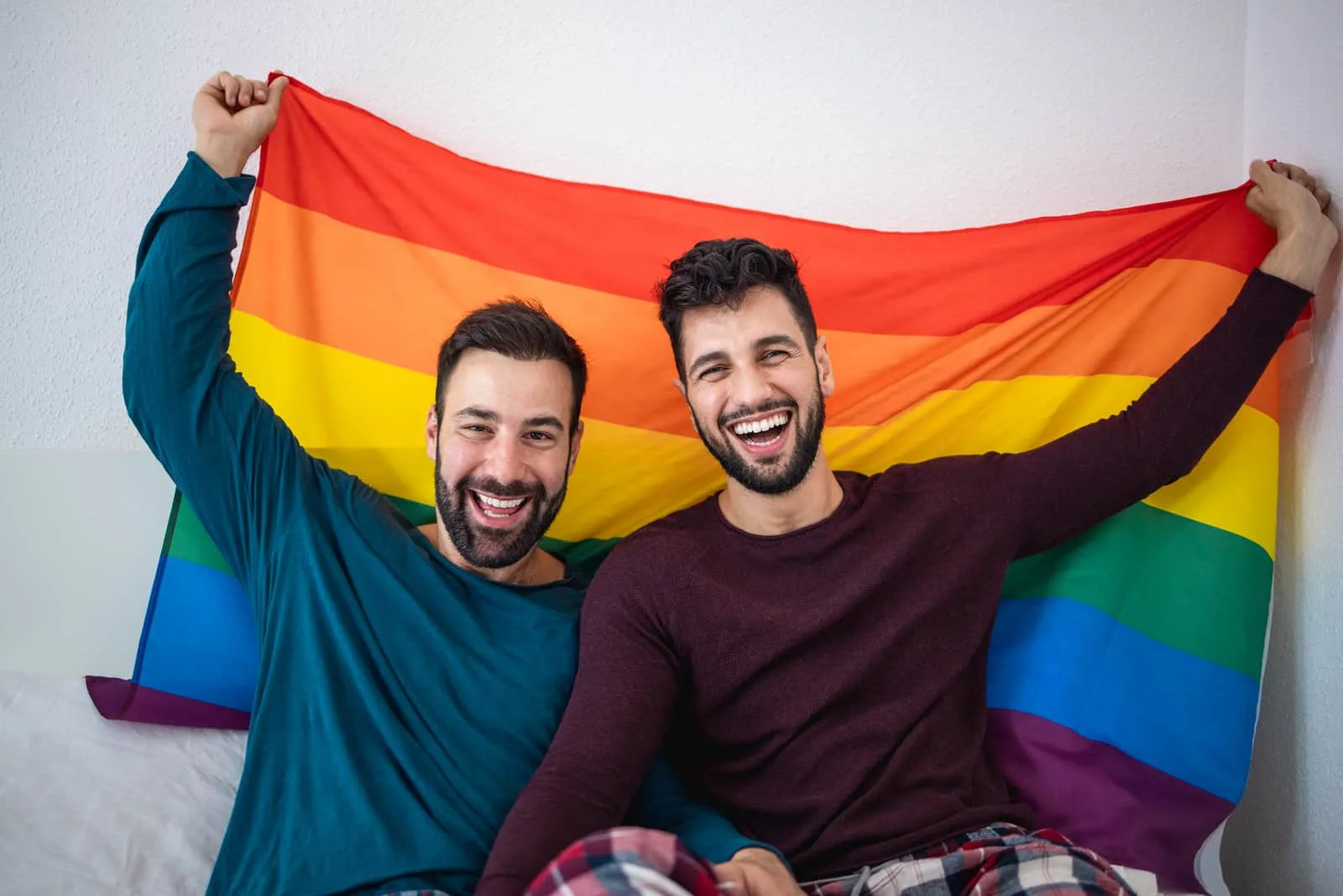 two man holding lgbt flag