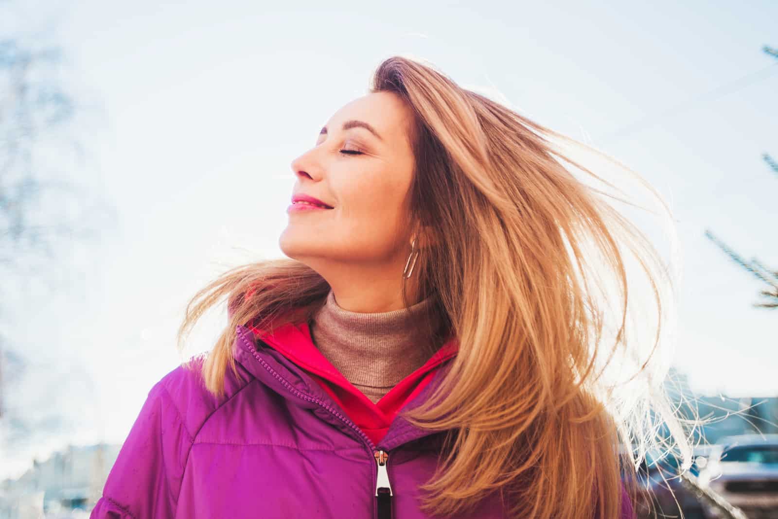 mujer sonriendo con los ojos cerrados