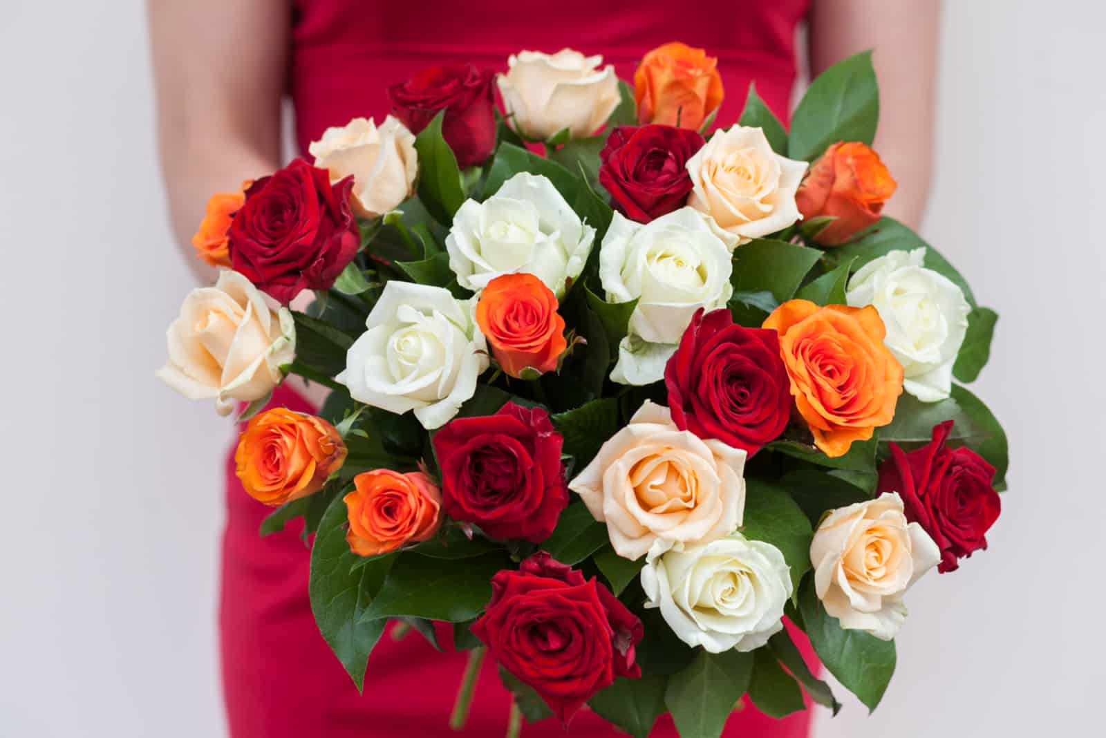 donne che tengono un bouquet di rose colorate