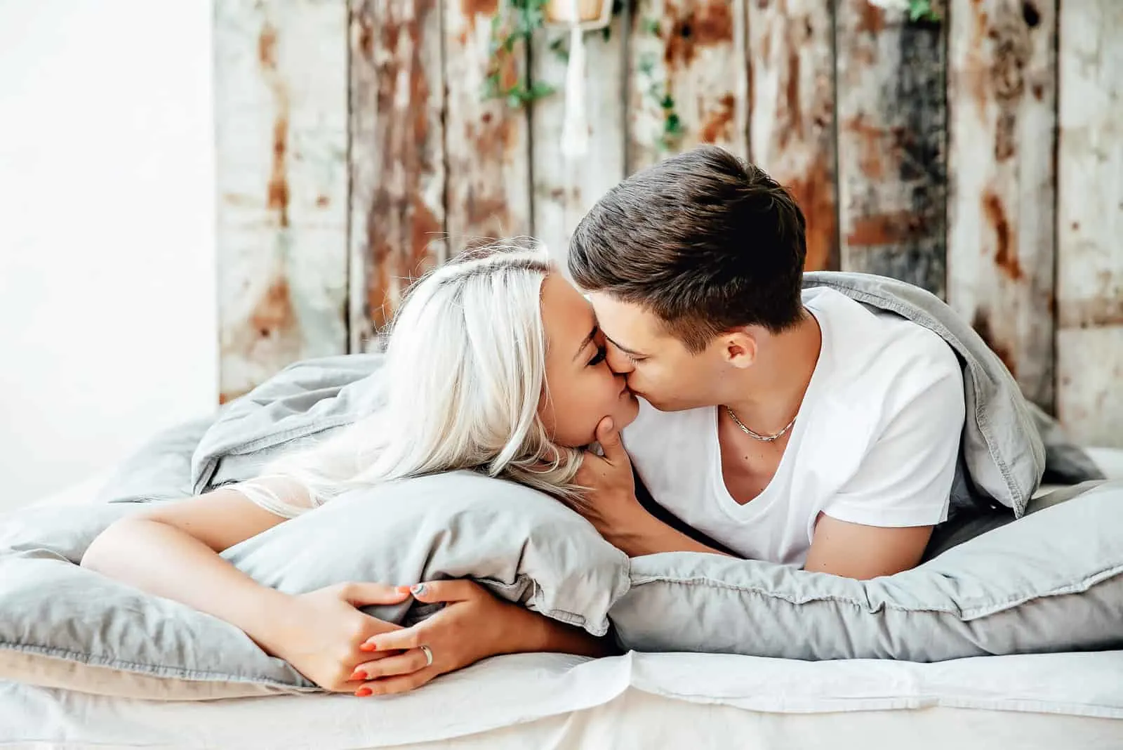 young couple kissing in the bed