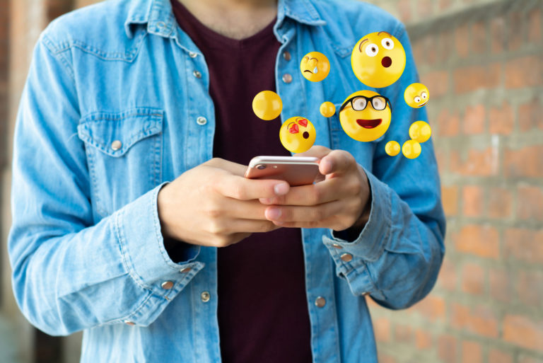 man sending an emojis over mobile phone