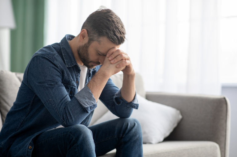 sad man sitting on sofa