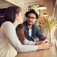 mujer hablando con su amigo en un café