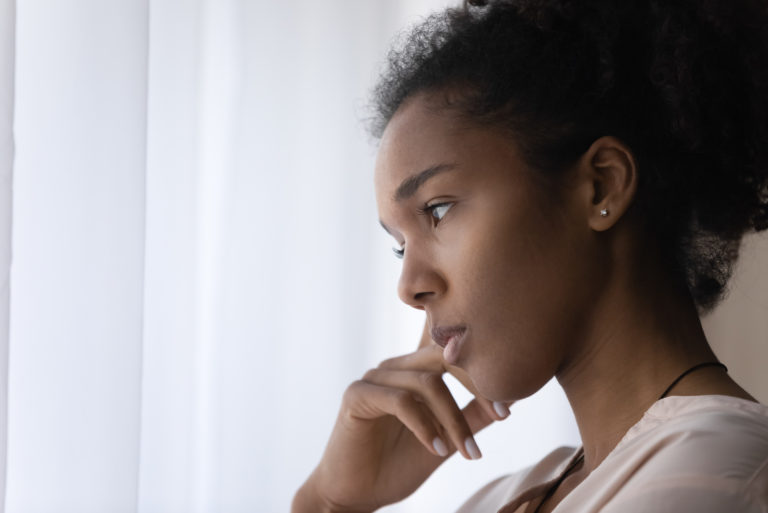 young woman in deep thoughts looking away