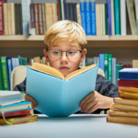 an indigo child reading a book in a library