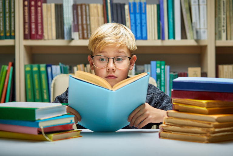 an indigo child reading a book in a library