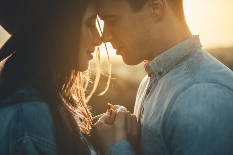 Close up of loving couple standing opposite to each other with closed eyes