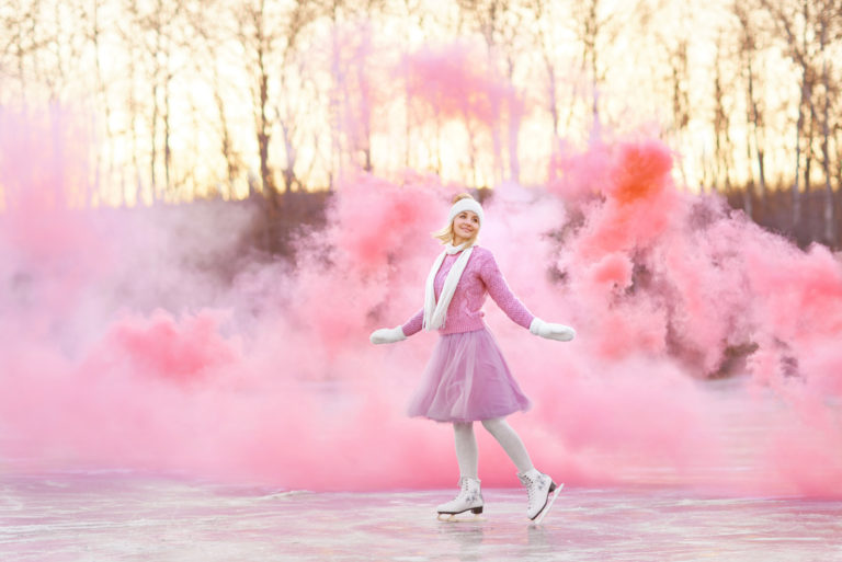 woman skating with pink smoke behind her
