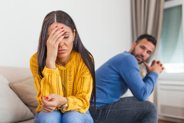 casal sentado no sofá depois de uma discussão