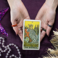 woman holding the empress tarot card in hands