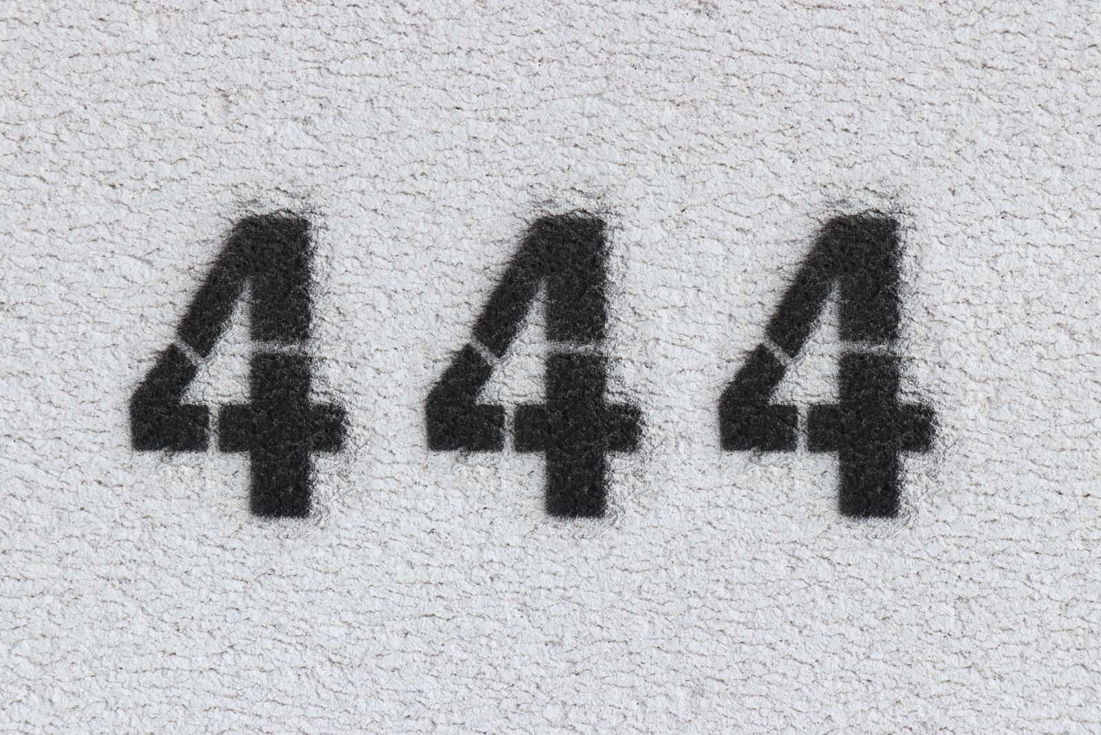 black number 444 on the grey wall