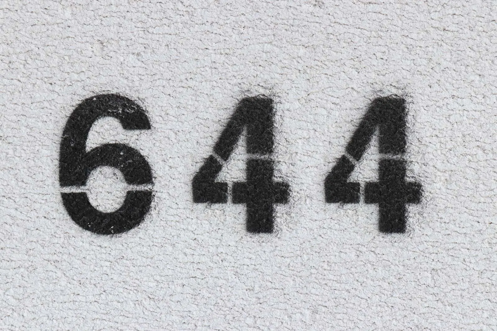 black number 644 on grey wall
