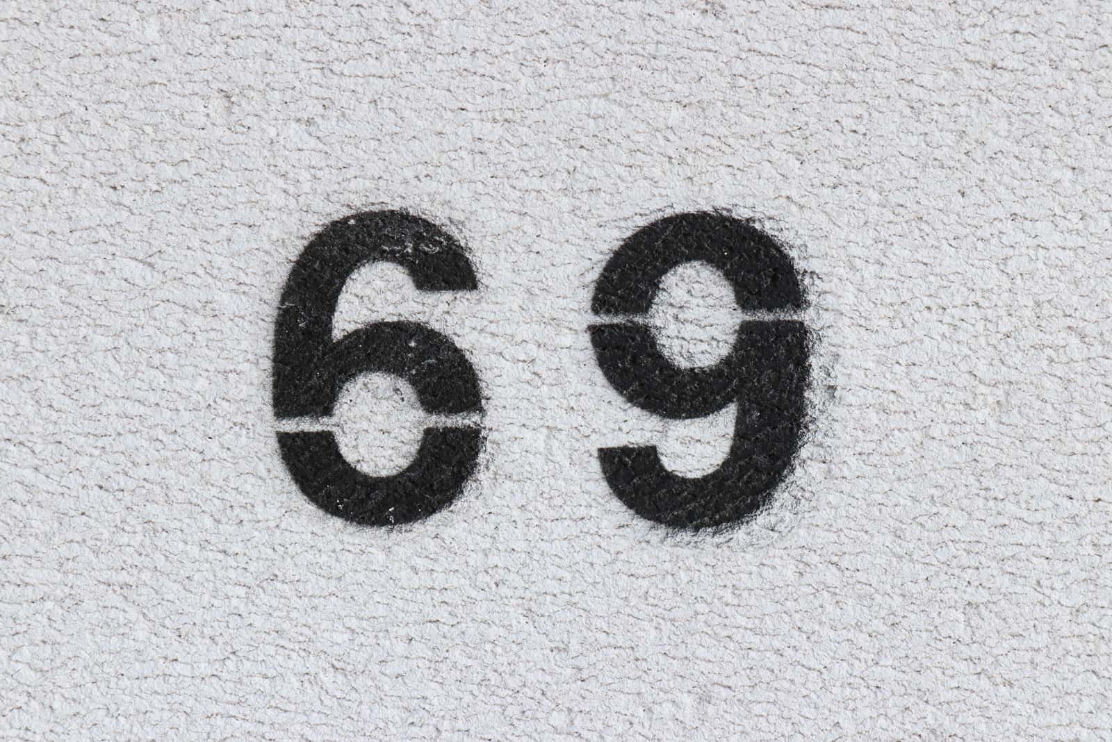 black number 69 on grey wall