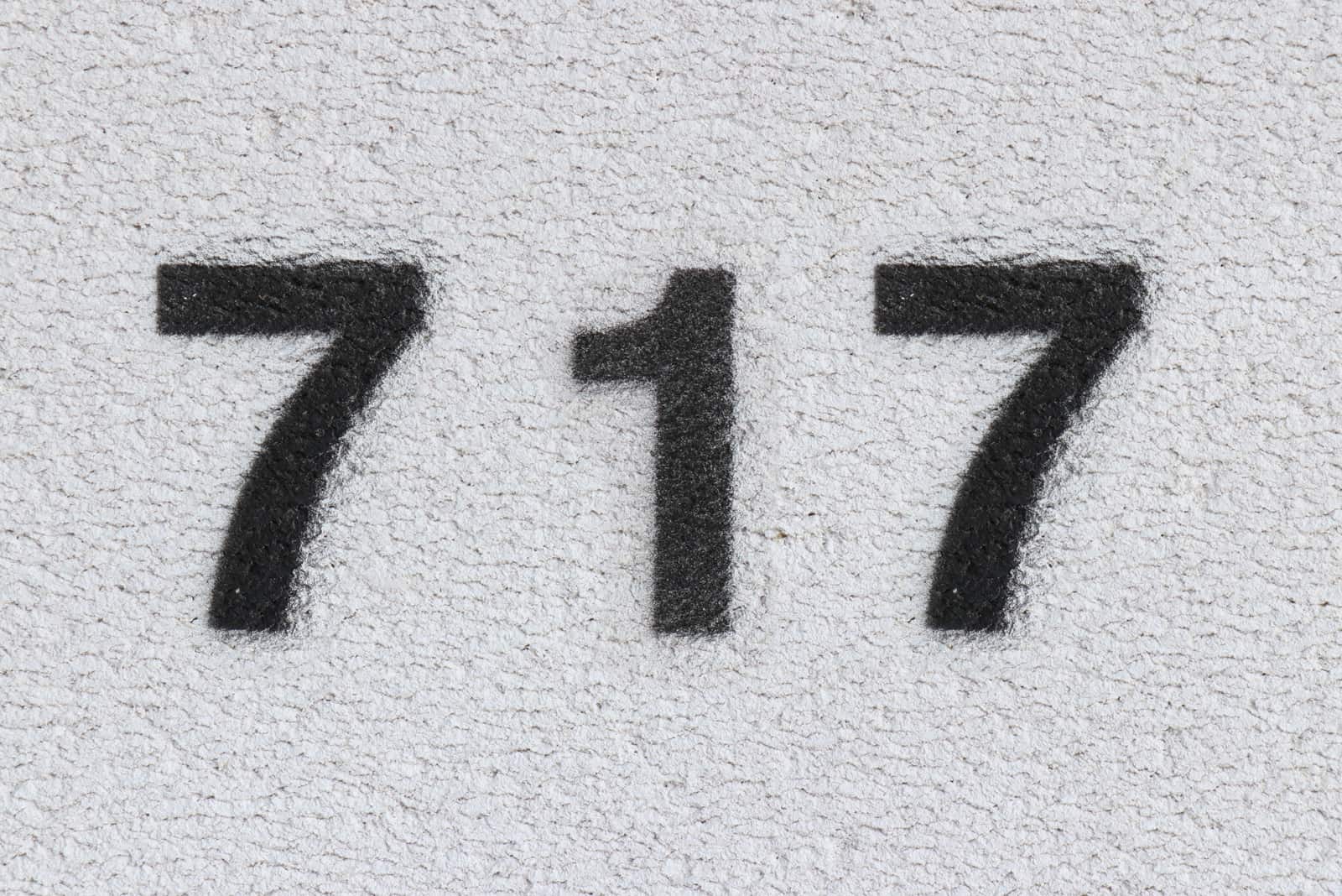 black number 717 on grey wall