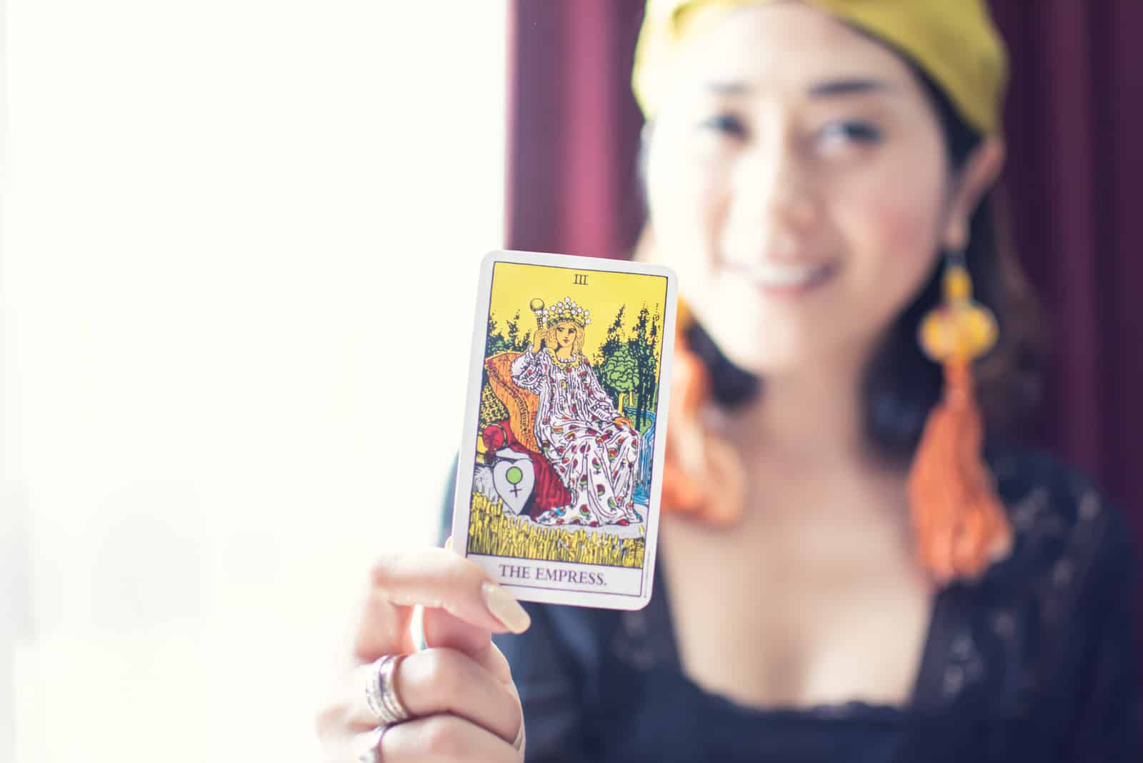 bohemian woman holding the empress tarot card